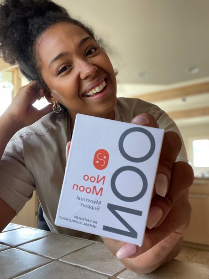 Sidney smiling with a Nooci supplement box