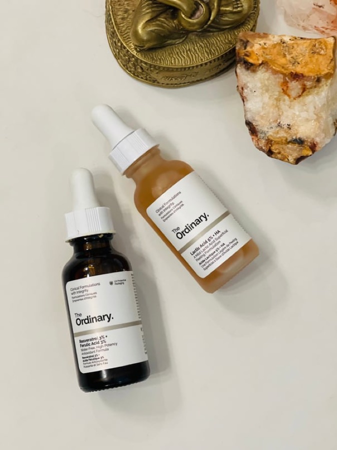 Two The Ordinary serum bottles with brass and crystal props